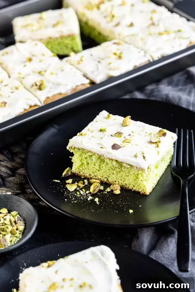 Pistachio cake topped with buttercream and chopped pistachios