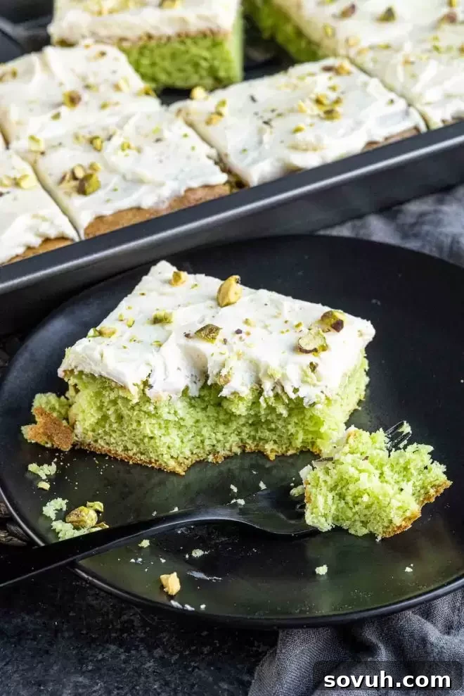 Pistachio cake with a slice removed, showing moist interior