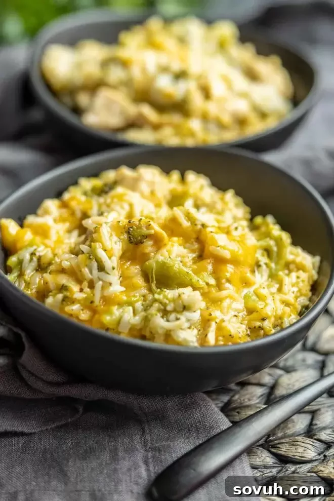 A vibrant bowl of Cheesy Instant Pot Chicken and Rice with visible pieces of broccoli and melted cheese.