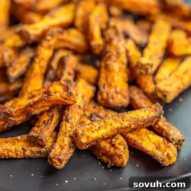 Crispy Air Fryer Sweet Potato Fries arranged on a plate with dipping sauce.
