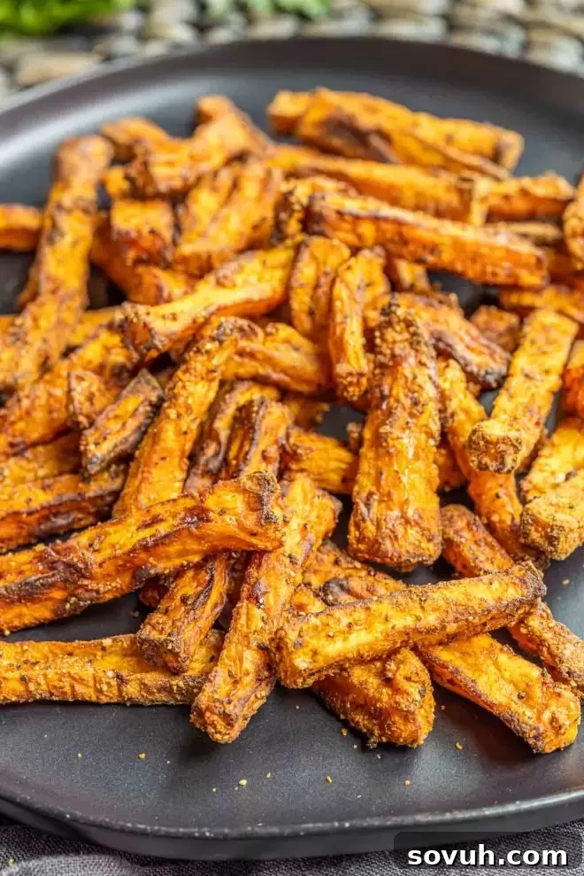 A plate piled high with crispy Air Fryer Sweet Potato Fries, garnished with parsley.