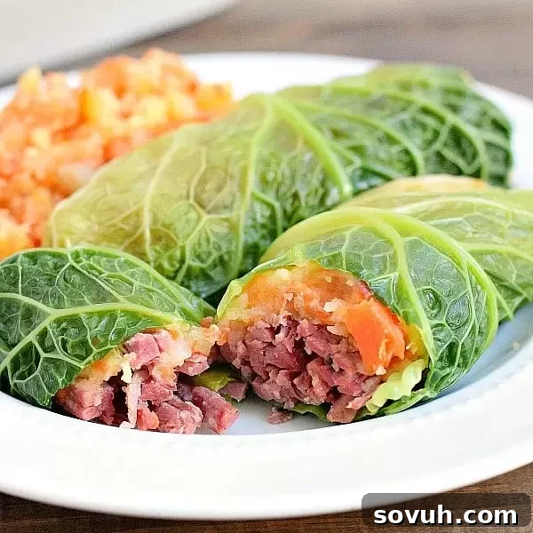 A corned beef cabbage roll cut open with corned beef and carrot parsnip filling, ready to serve.