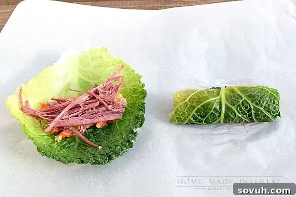 Chef demonstrating how to roll corned beef and carrot parsnip mash into a cabbage leaf.