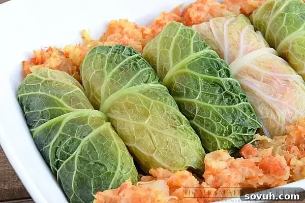 A casserole dish filled with baked corned beef cabbage rolls, surrounded by extra mash.