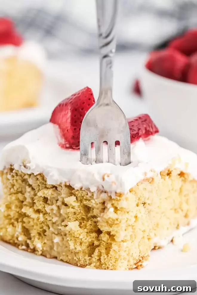 Tres Leches Cake on a plate with a fork in it