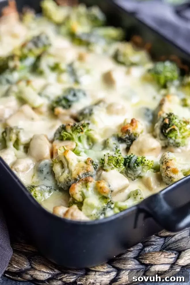 Keto Chicken and Broccoli Alfredo Casserole served with a scoop, showing creamy interior