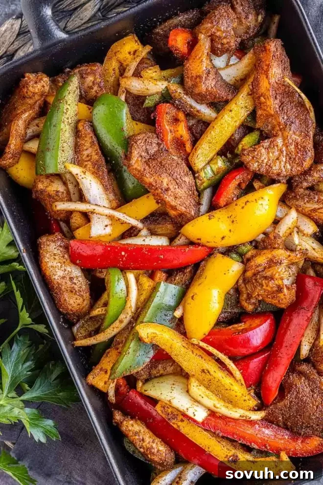 One-Pan Chicken Fajita Bake 4 Raw chicken and sliced bell peppers and onions coated in fajita seasoning in a bowl