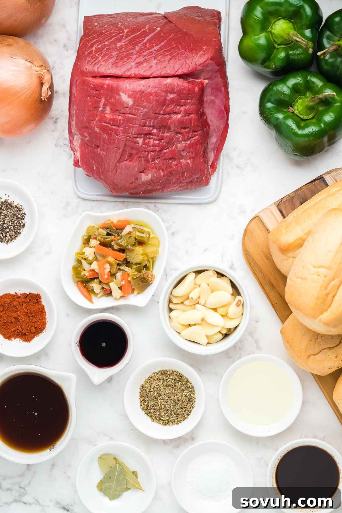 Ingredients laid out for making Crock Pot Italian Beef, including a beef roast, vegetables, and seasonings.
