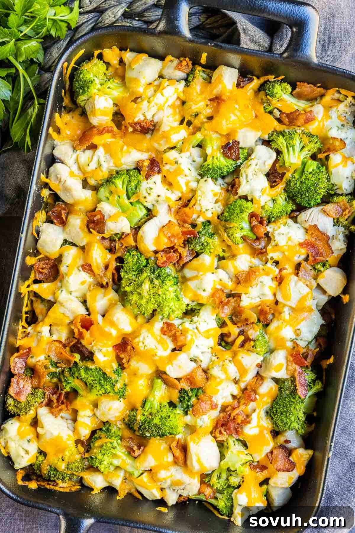 A large platter of golden-brown Keto Chicken Bacon Ranch Casserole, topped with melted cheese and crispy bacon, ready to be served