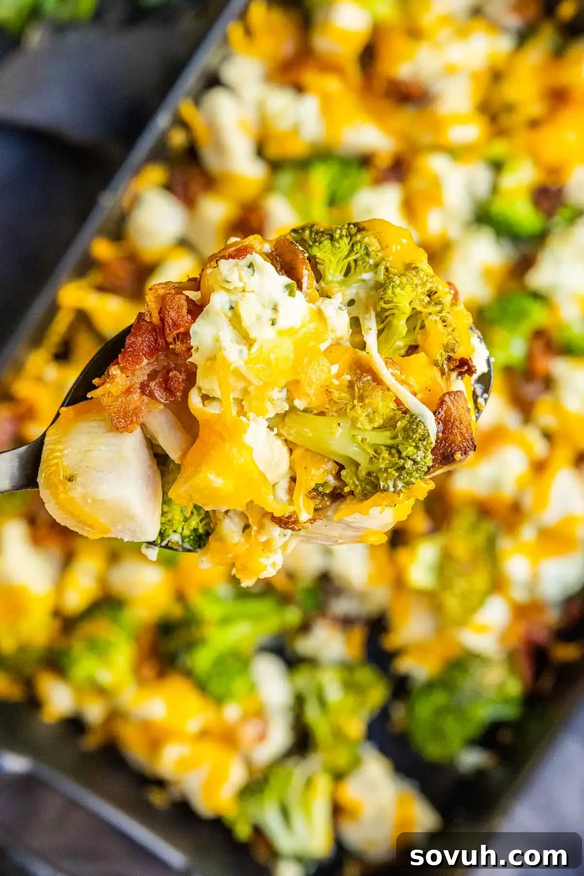 A full spoon of Keto Chicken Bacon Ranch Casserole, ready to be enjoyed, highlighting its rich textures and appealing colors