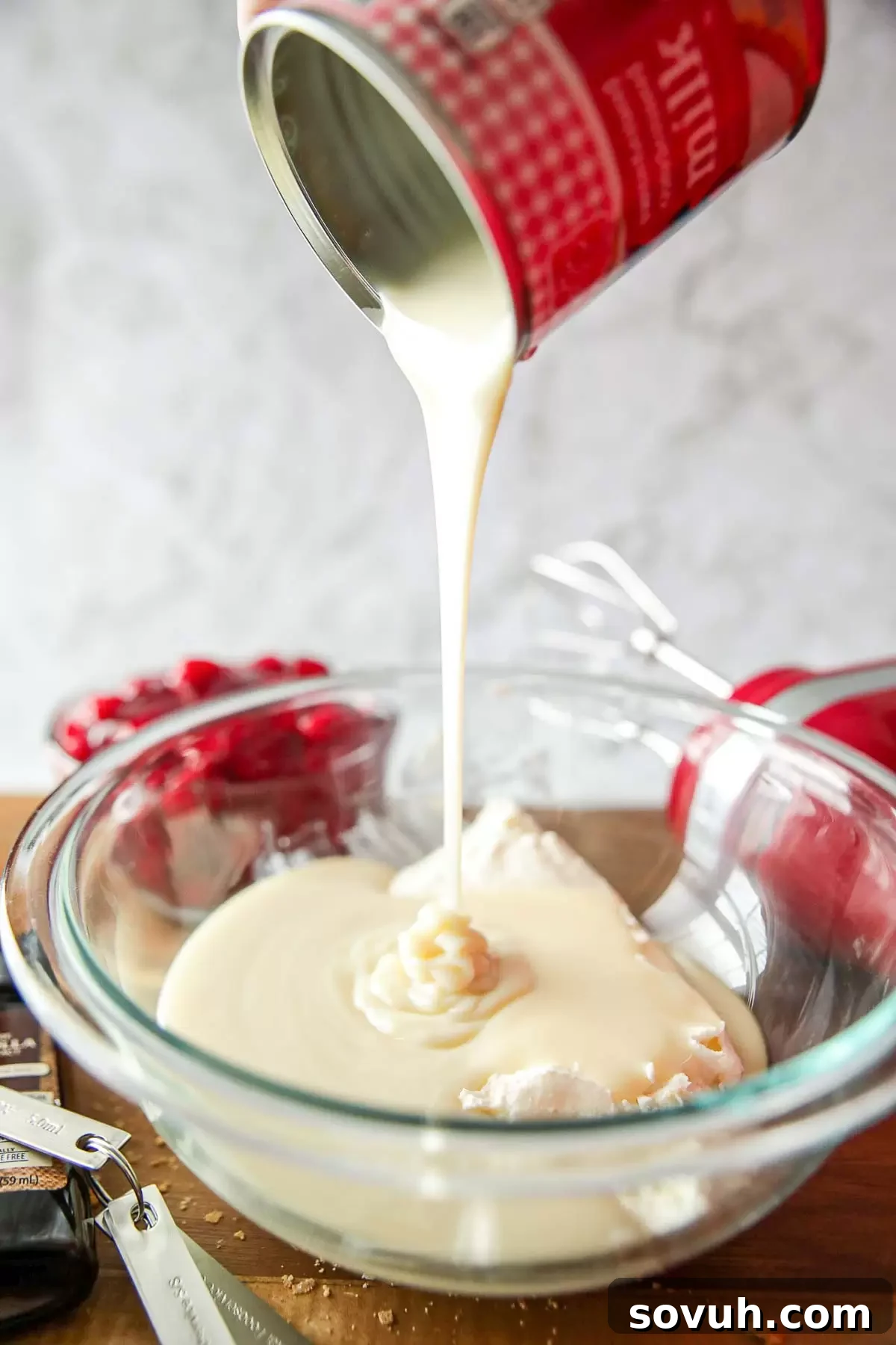 Creamy cheesecake filling in a bowl, ready to be spooned into no-bake graham cracker crusts.