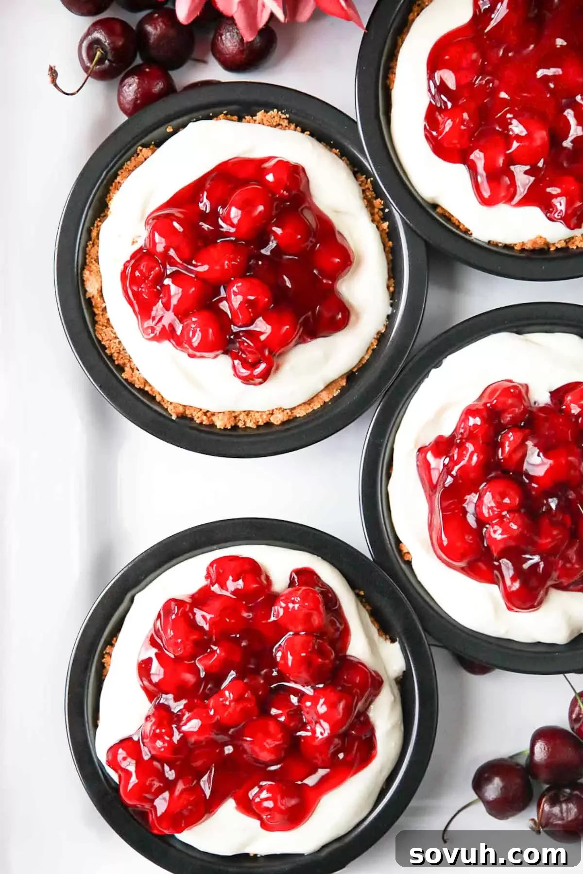 A tray of mini No Bake Cherry Cheesecakes, ready to be topped and served, showcasing their smooth, creamy filling.