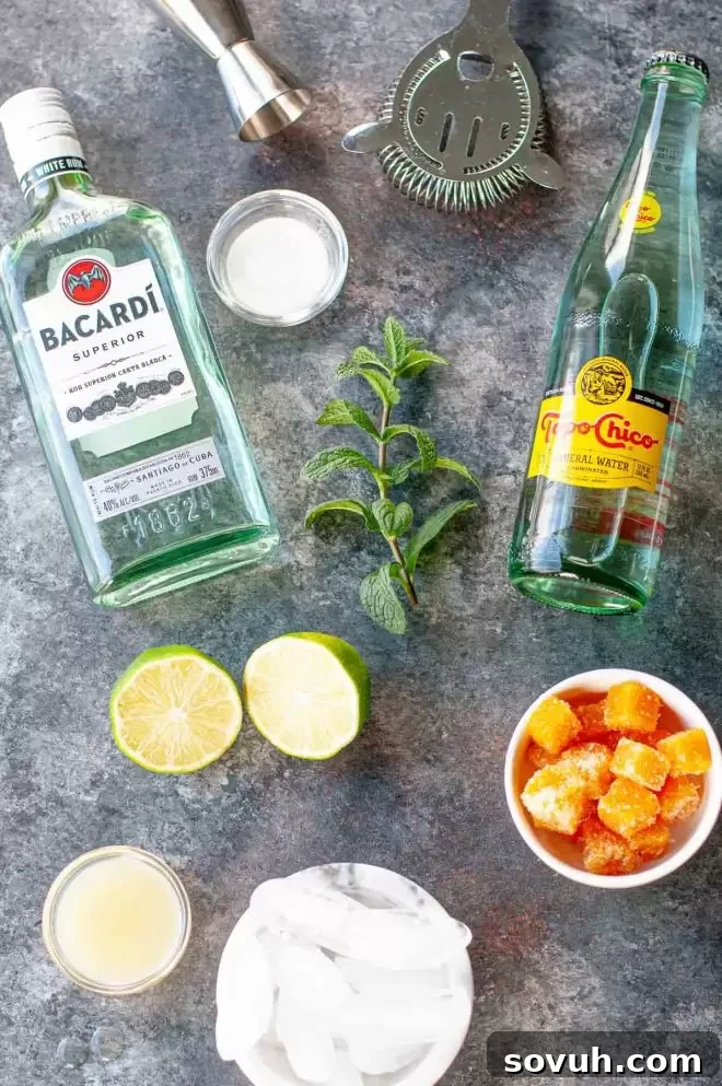 Essential ingredients laid out for a Passion Fruit Mojito, including fresh limes, mint, passion fruit puree, and rum.