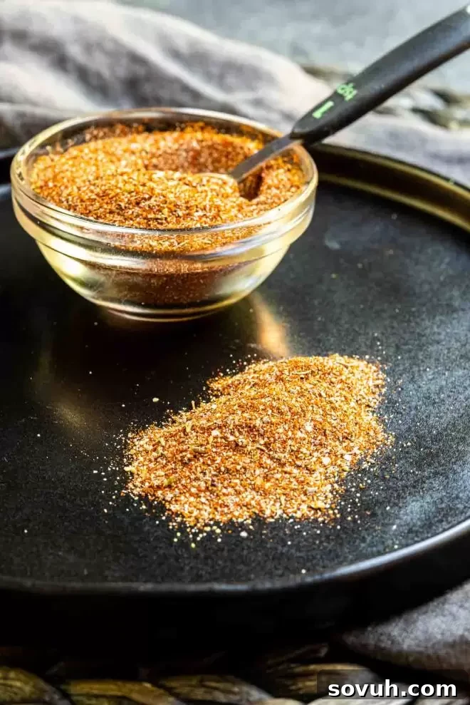 Blackened Seasoning on a black plate with cup of seasoning