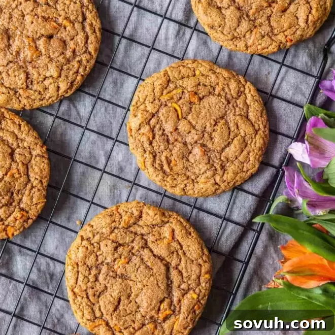 A charming display of Carrot Cake Mix Cookies on a cooling rack, garnished with delicate flowers.