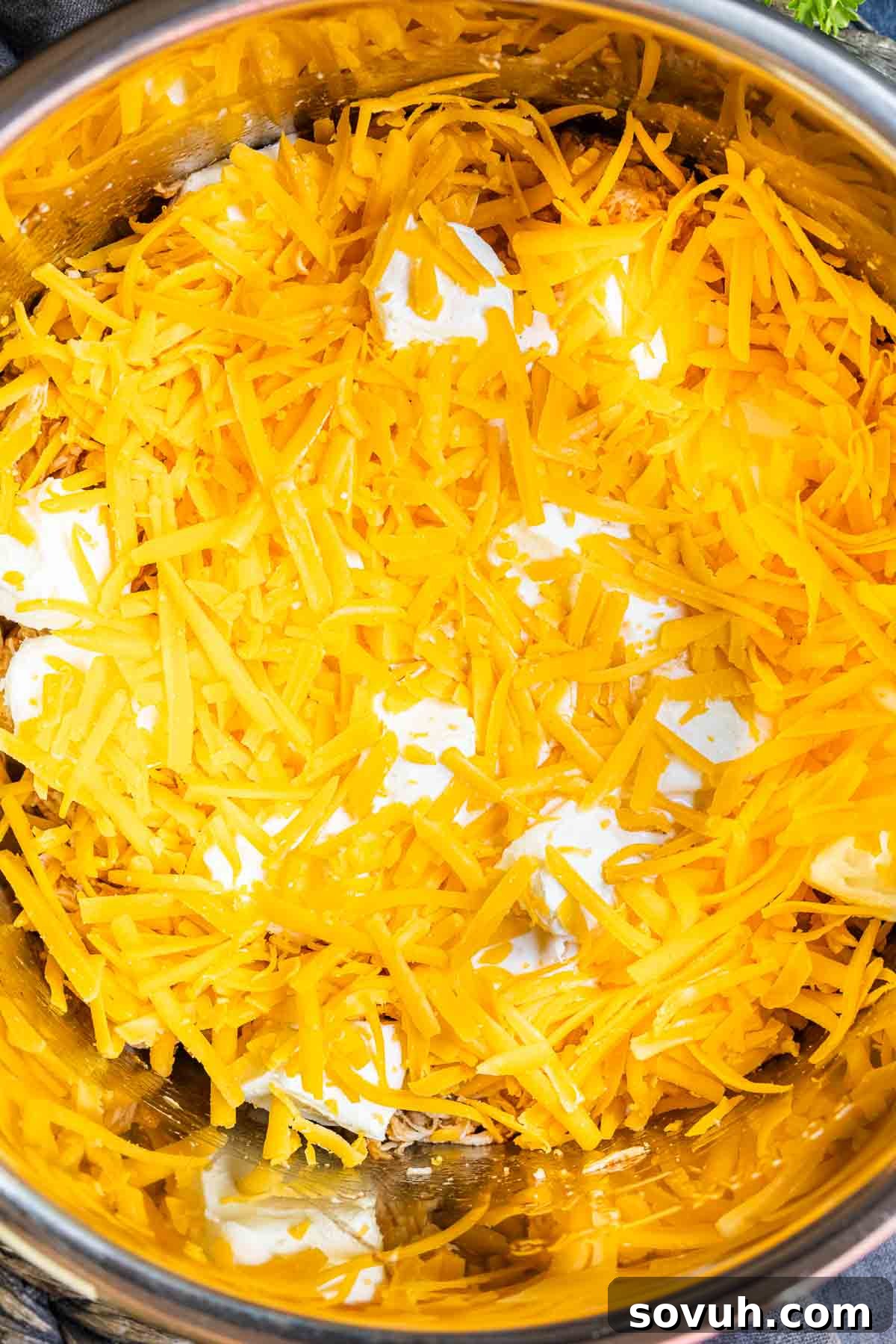 Instant Pot Buffalo Chicken Dip with shredded cheddar cheese and cream cheese