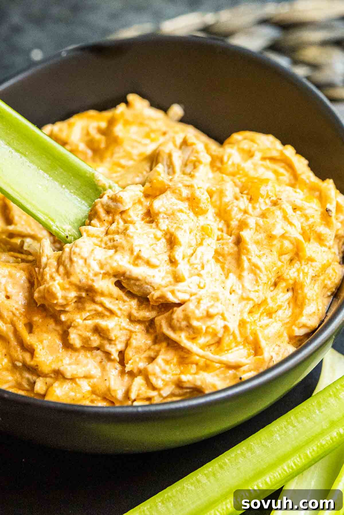 bowl of Instant Pot Buffalo Chicken Dip with celery stick in it