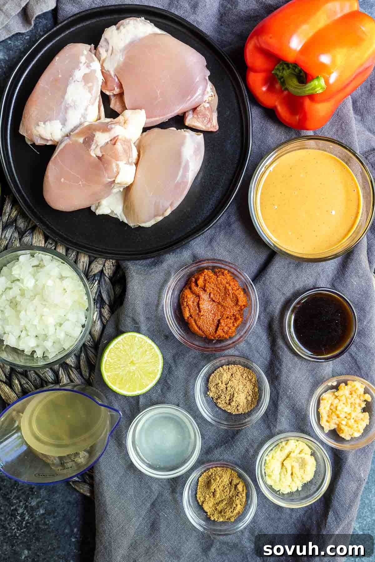 All the ingredients for Keto Peanut Butter Chicken laid out on a wooden cutting board.