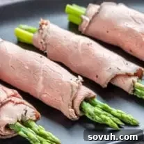 Roast Beef and Asparagus Roll Ups on a black platter