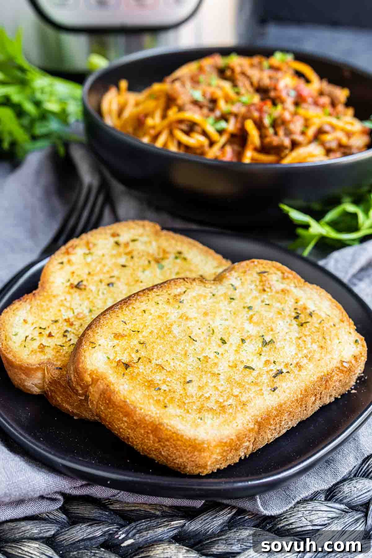Texas Toast on a plate with spaghetti in a bowl