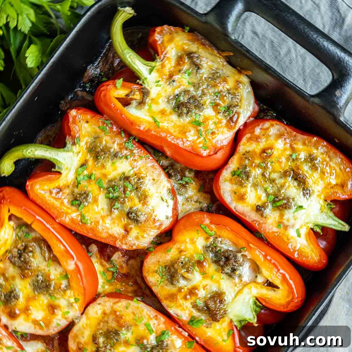 Lasagna Stuffed Peppers in black dish, garnished with fresh herbs, ready to be served.