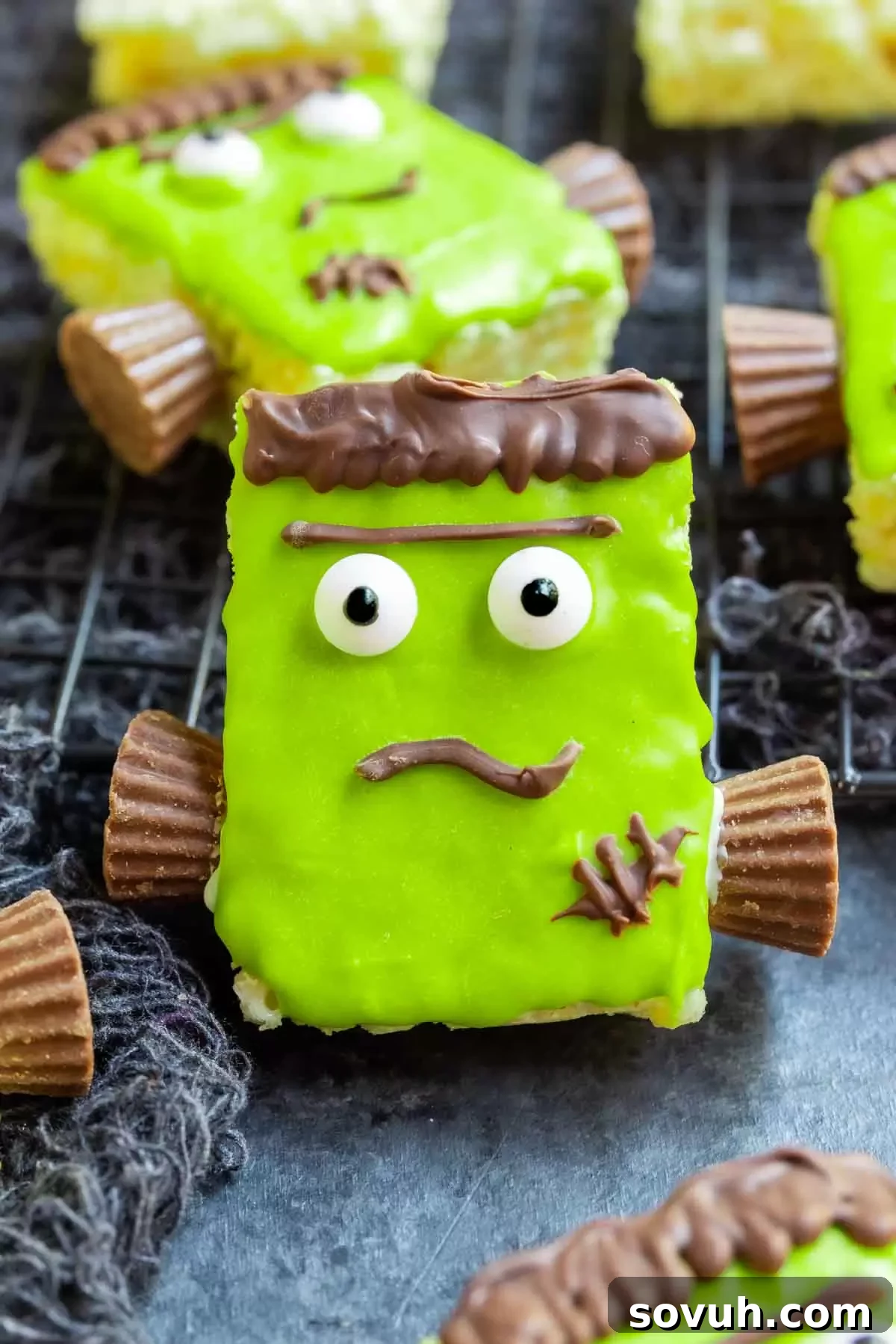 A close-up of a Frankenstein Rice Krispies Treat, decorated with green candy melts, candy eyes, and chocolate details.