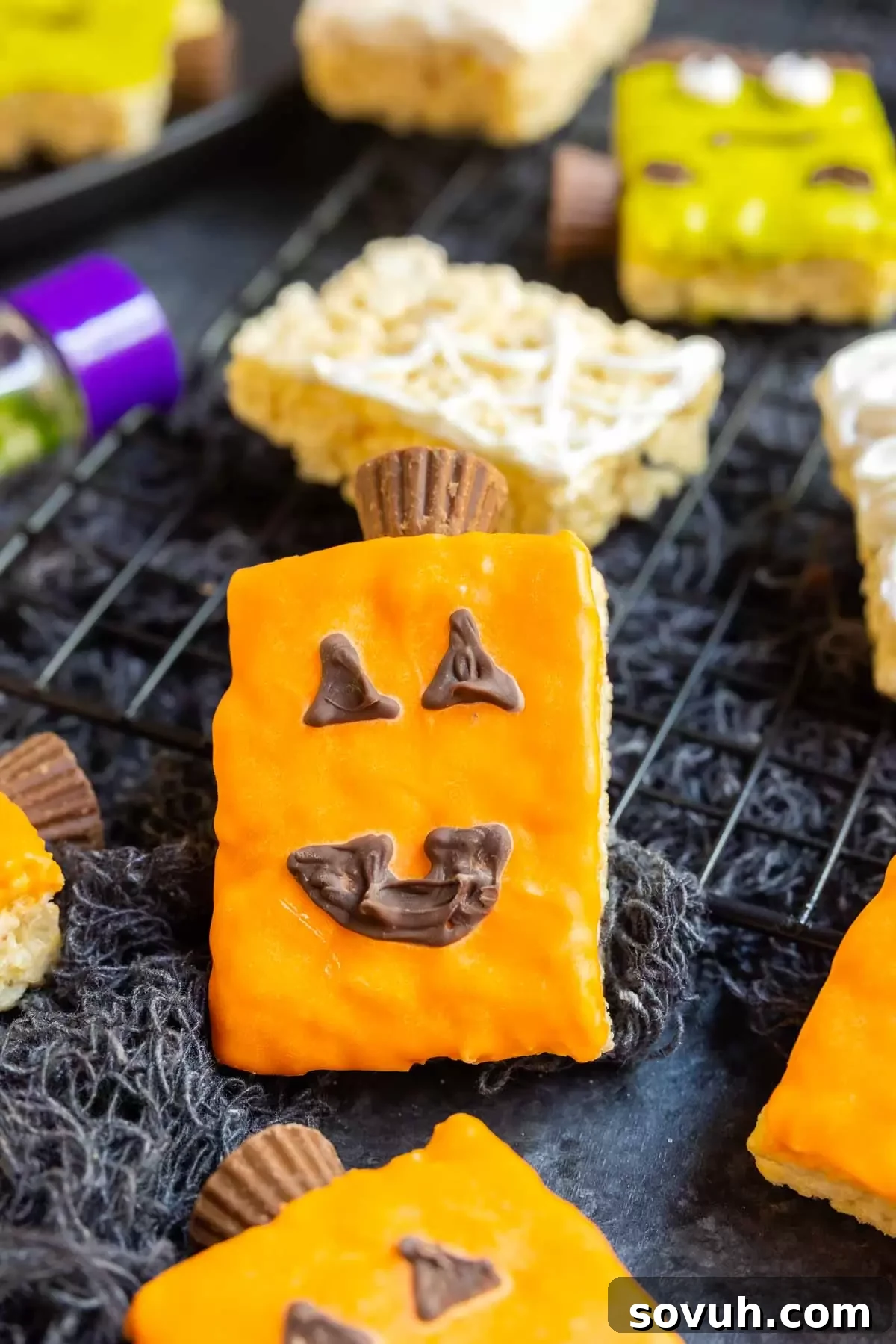 A festive Pumpkin Rice Krispies Treat adorned with orange candy melts and a chocolate jack-o'-lantern face.