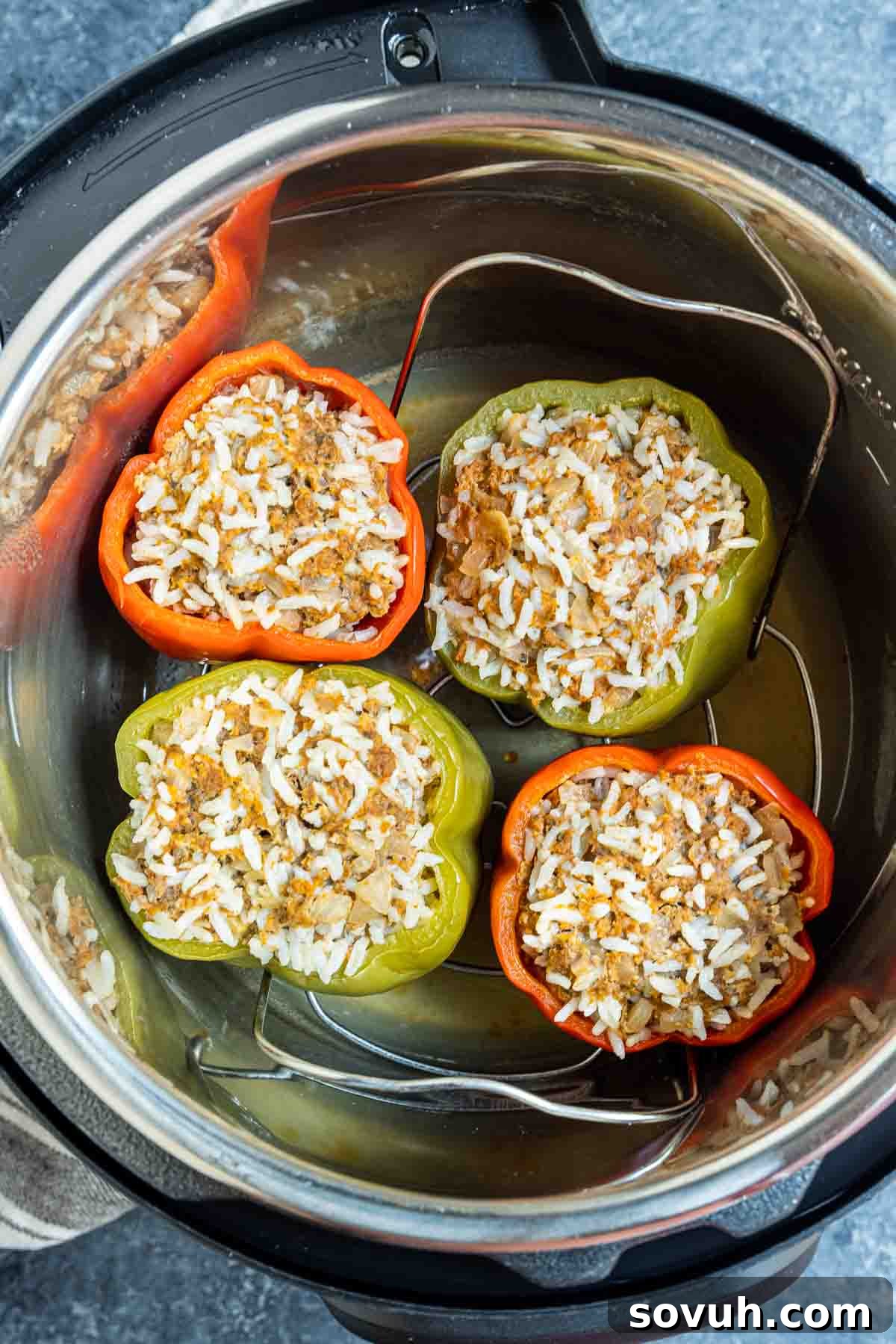 Cooked Instant Pot Stuffed Peppers with melted cheese, still in the Instant Pot basket