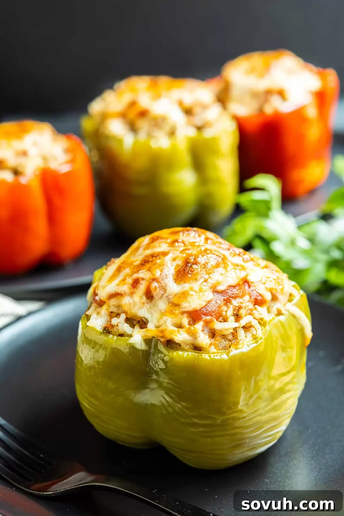 Instant Pot Stuffed Peppers on black plate, garnished with fresh herbs