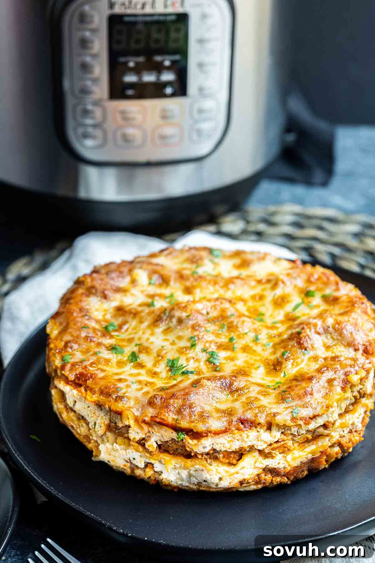 Instant Pot Lasagna on black platter with Instant pot behind it