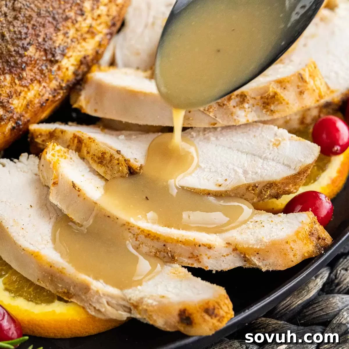 Homemade Turkey Gravy generously poured over succulent slices of roasted turkey breast, glistening under warm light.