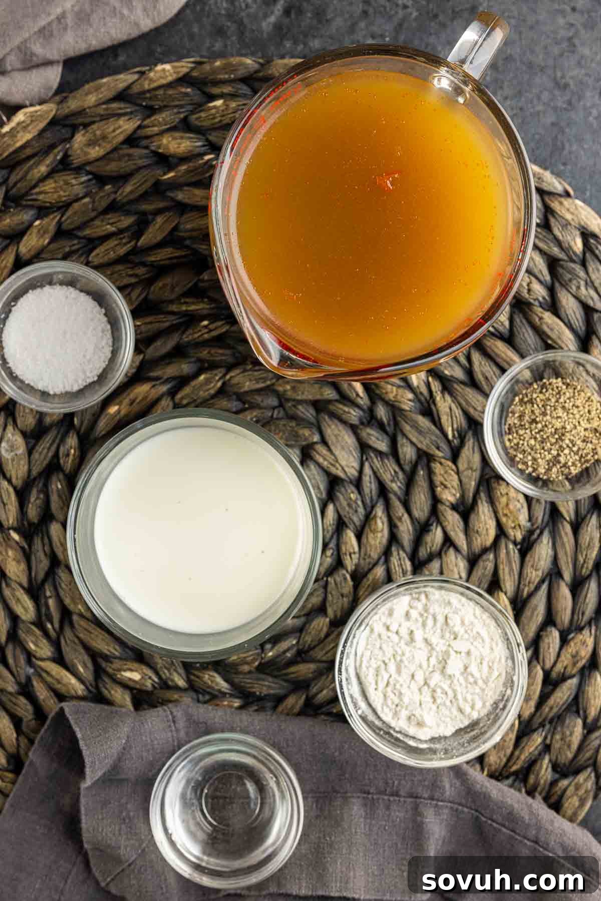 Fresh ingredients for Homemade Turkey Gravy including broth, flour, and a whisk.