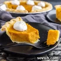sweet potato pie on a black plate with fork