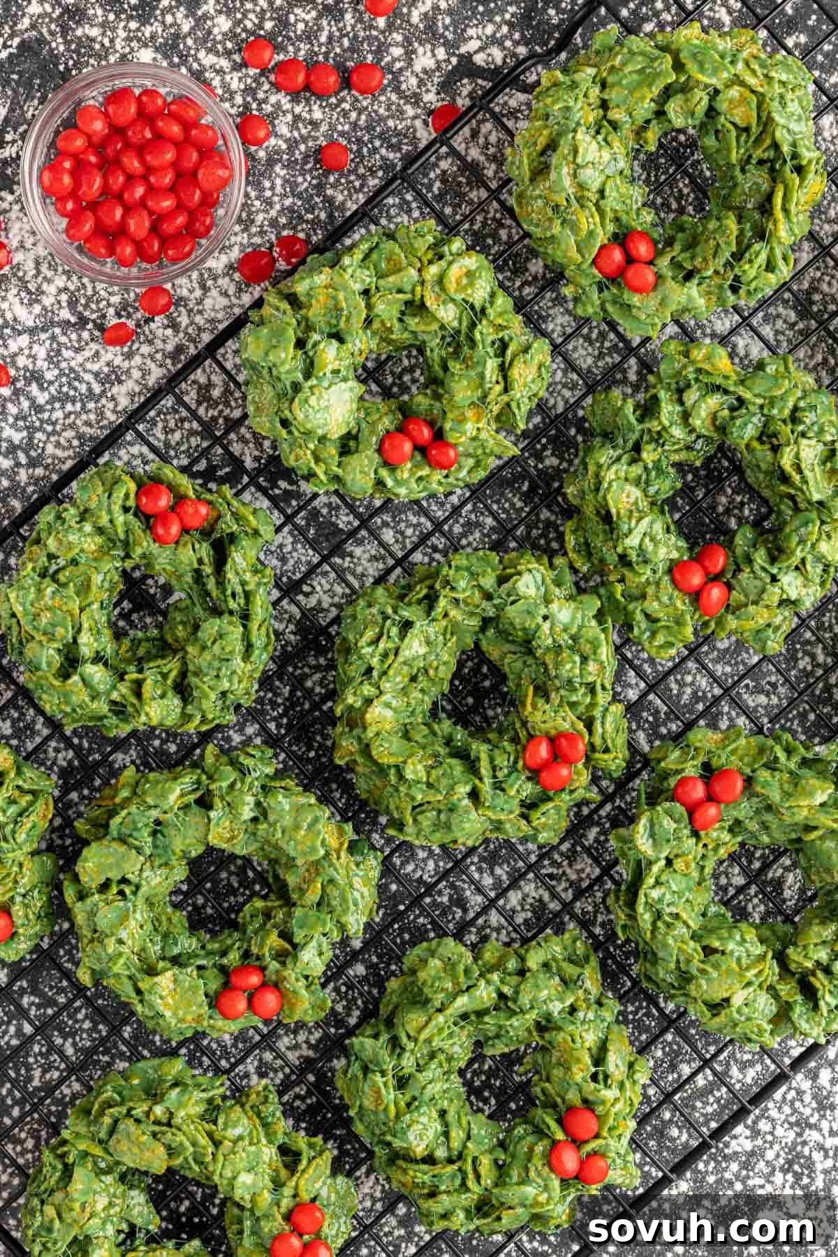 Close-up of festive Christmas Wreath Cookies adorned with red hot candies, showcasing their crispy texture.