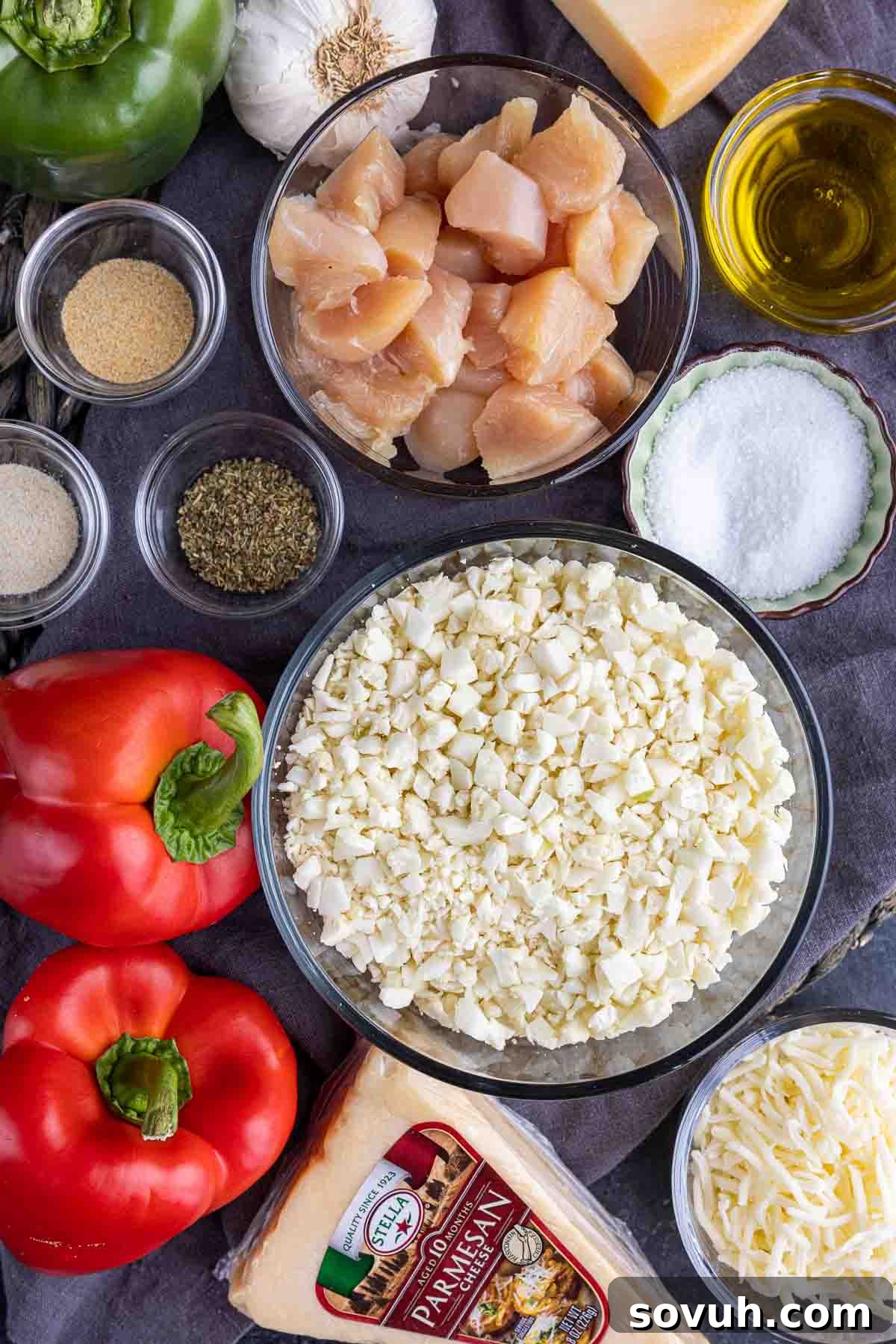 Creamy Keto Chicken Alfredo Stuffed Peppers 3 A vibrant selection of fresh ingredients laid out for Keto Chicken Alfredo Stuffed Peppers, including bell peppers, chicken, cauliflower rice, and cheeses