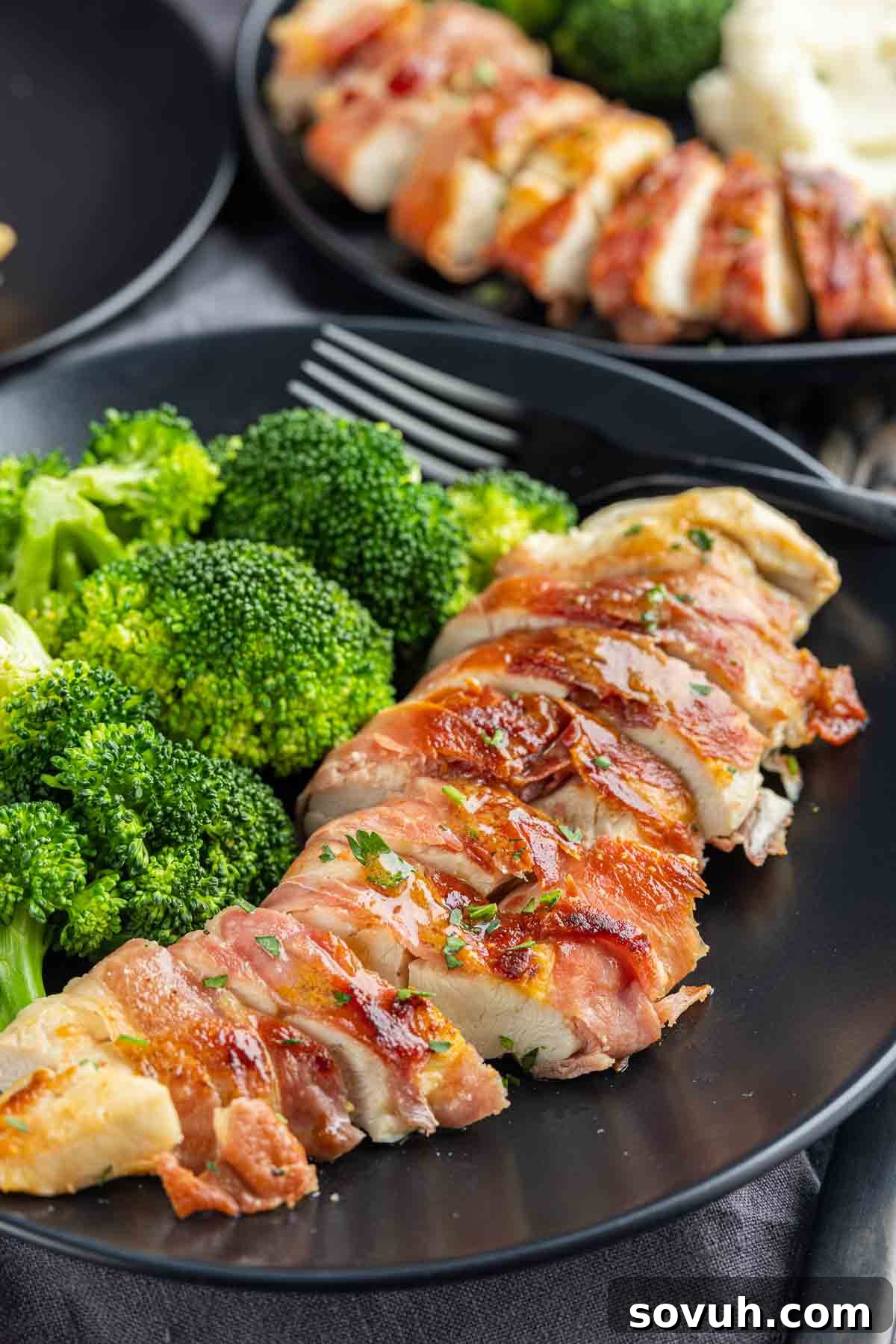 Sliced Prosciutto Wrapped Chicken served on a plate with a side of broccoli.
