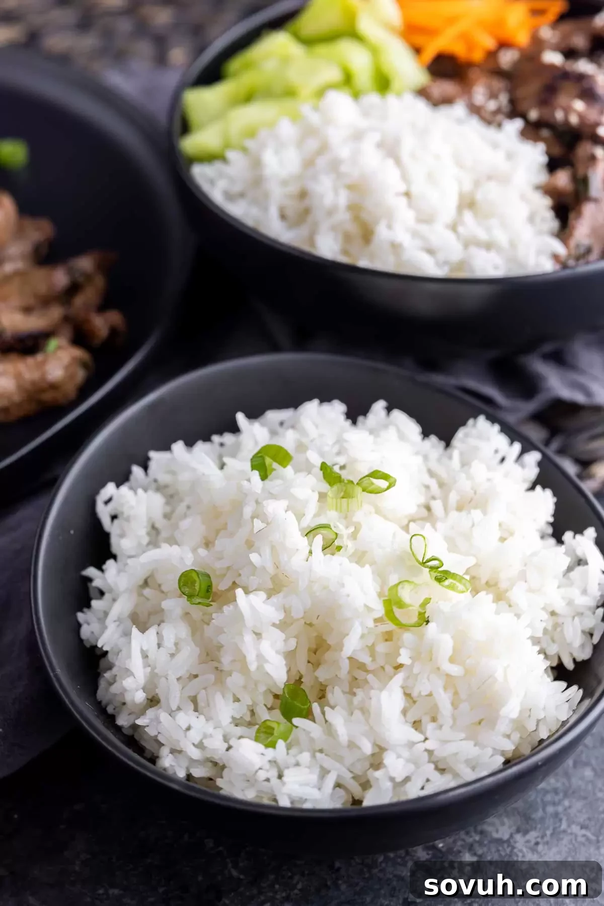 Two serving bowls filled with Instant Pot White Rice, garnished and ready.