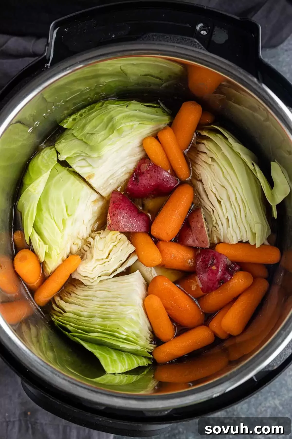 Detailed image showing the corned beef brisket placed on top of onions and garlic within the Instant Pot, ready for pressure cooking.