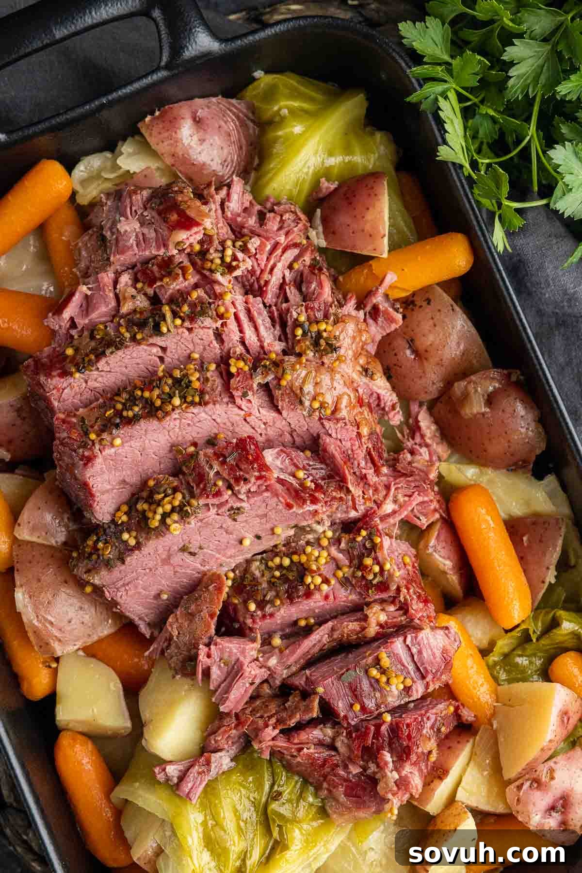 Close-up of a black platter showcasing perfectly sliced, tender Instant Pot Corned Beef, ready to be served.