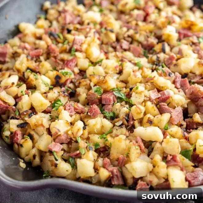 A skillet filled with golden-brown Corned Beef Hash, showcasing crispy potatoes, onions, and succulent corned beef.