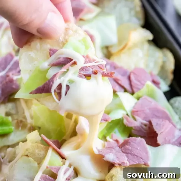 A platter of easy Irish Nachos, featuring crispy potato chips loaded with savory corned beef, fresh cabbage, and a rich homemade beer cheese sauce, ideal for sharing.