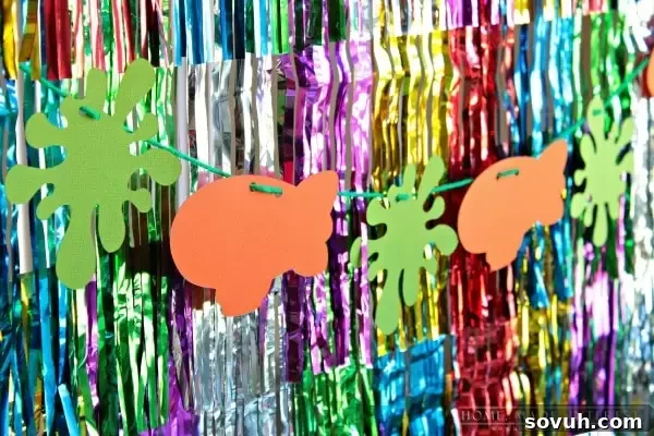 The decorated food table for a Kids' Choice Awards party, featuring a sparkly foil curtain and a DIY Nickelodeon banner.