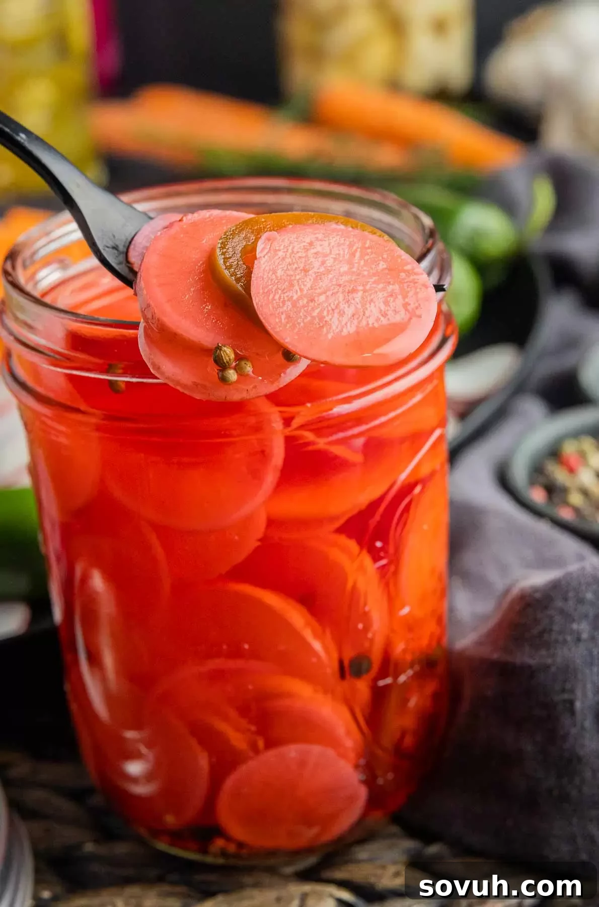 black fork with sliced Pickled Radishes and jar of Pickled Radishes