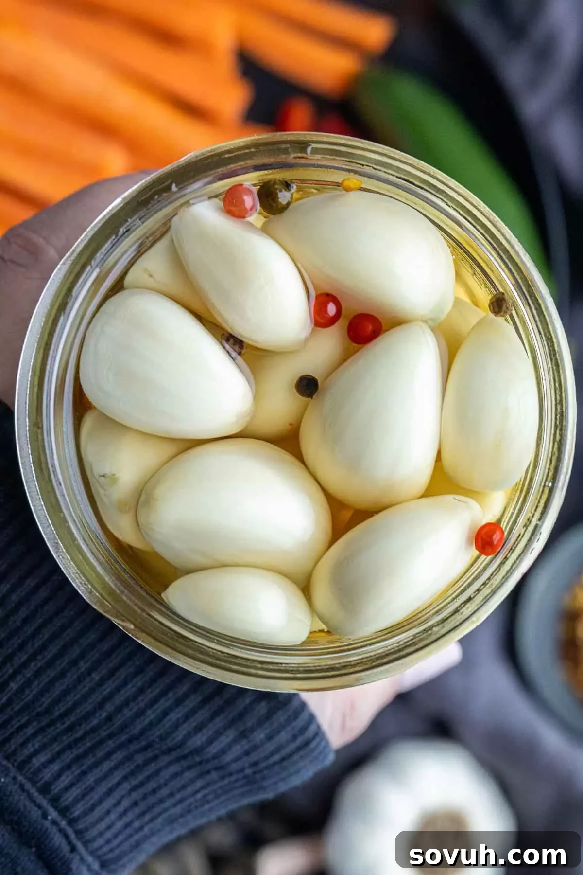 holding a jar of Pickled Garlic