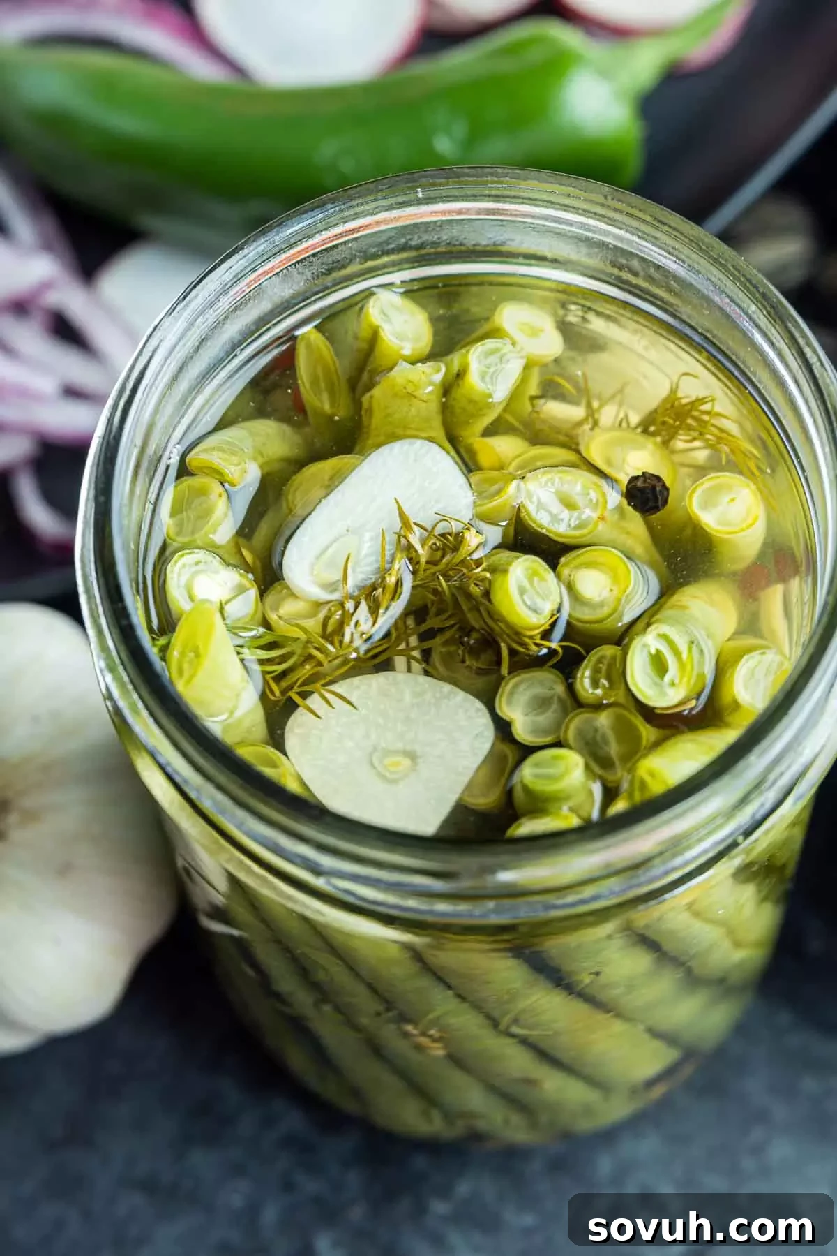 mason jar of Pickled Green Beans and sliced garlic