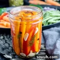 A glass jar filled with vibrant quick pickled carrots, ready to be enjoyed.