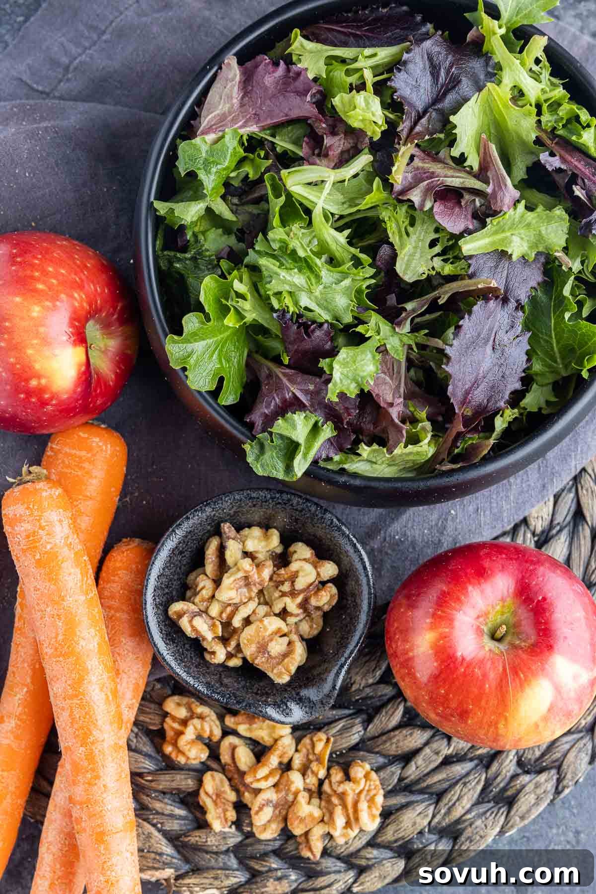 apples, carrots, walnuts and greens in a bowl to make Apple Walnut Salad