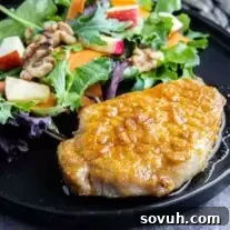 Air Fryer Honey Garlic Pork Chops on a black plate with walnut salad