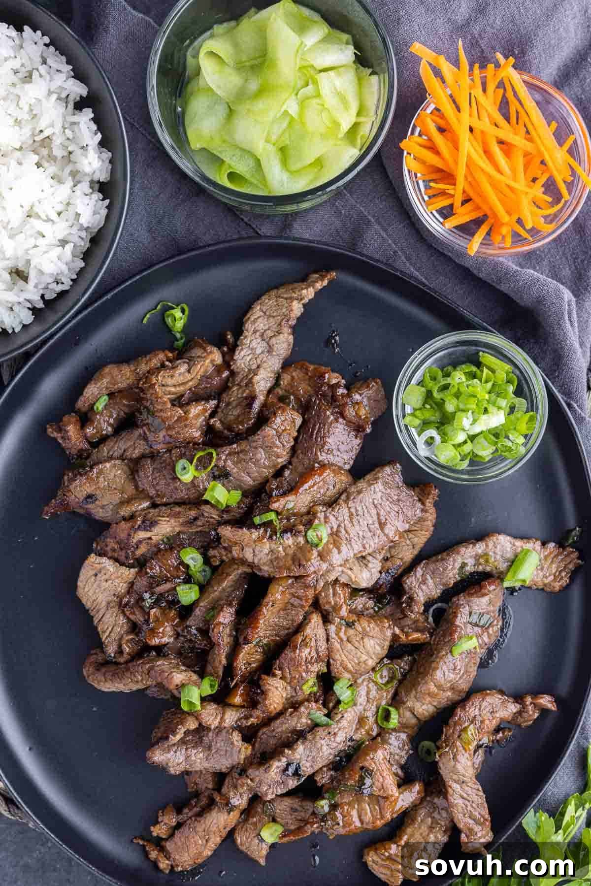 Beef Bulgogi on a plate with rice, cucumber ribbons and carrot sticks