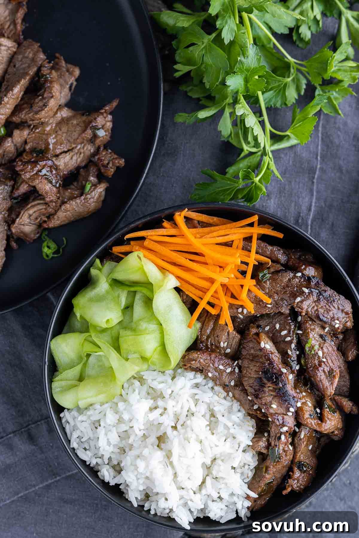 Beef Bulgogi bowl with rice, cucumbers ribbons, and carrot matchsticks